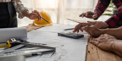 team engineer checks construction blueprints on new project with engineering tools at desk in office