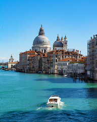 Fototapeta na wymiar Stunning view of the Venice skyline with the Grand Canal and Basilica Santa Maria Della Salute in the distance from Ponte Dell’ Accademia in a sunny weather with clear sky. Veneto, Italy