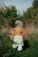 one year old boy takes his first steps in nature and explores his environment