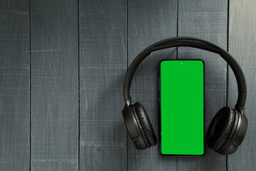 Big wireless headphones and phone. Chromakey space on the phone screen
