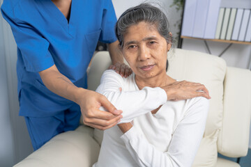 Female asian physiotherapist worker giving neck massage to mature woman, closeup. Rehabilitation physiotherapy in rehabilitation center, neck pain