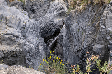 Close view of the rocks and the stream in the volcanic gorge of Gore Alcantara Botanical and ...