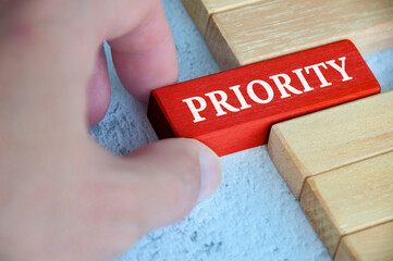 Hand placing red wooden blocks with text - Priority. Priority and business concept