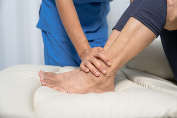 Fototapeta na wymiar Female asian physiotherapist worker giving leg massage to senior woman, closeup. Rehabilitation physiotherapy in rehabilitation center, muscle weakness, Calf and knee pain