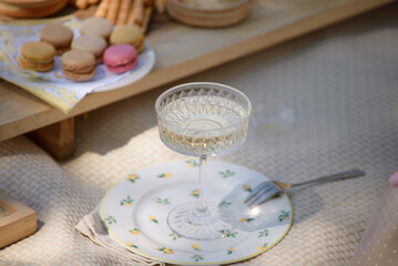 A glass of champagne and a cake in a clearing