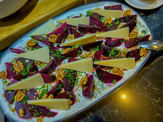 salad of pieces of boiled beets, slices of cheese, walnuts, parsley, dill. everything is on hummus.