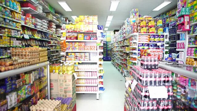 Fixed clip of full grocery store shelves, filled with brightly coloured products