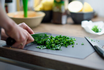 Girl cook cuts greens. Green borscht