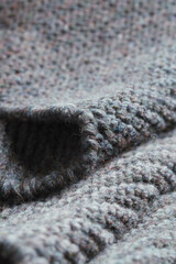 Dark gray zigzag knitted fabric. Knitted texture.
