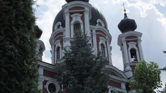 Tall Red Painted Orthodox Church Hidden Among Trees