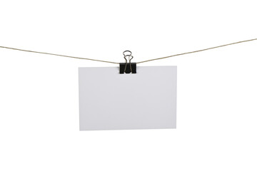 Tarjeta blanca colgando de una cuerda sujetada por una pinza de metal negro - obrazy, fototapety, plakaty