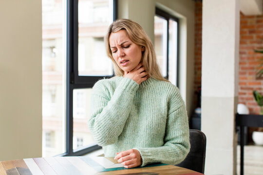 young pretty woman feeling ill with a sore throat and flu symptoms, coughing with mouth covered