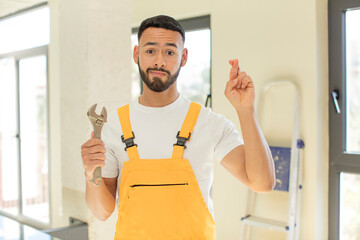 arab handsome man arab man crossing fingers and hoping for good luck. handyman with a wrench