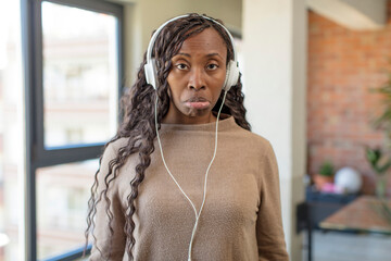 black afro woman feeling sad and whiney with an unhappy look and crying. listening music concept