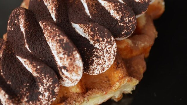 Closeup top view of Rotating chocolate powder amd cream  on waffles
