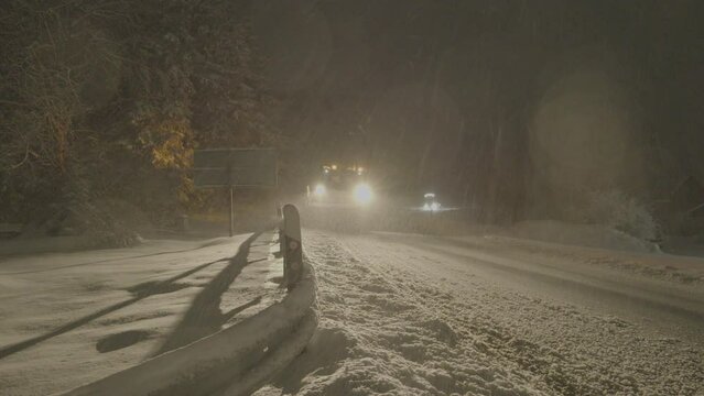 Snow plow clearing a road at nigh, Winterberg, Germany