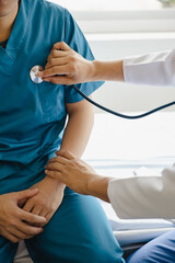 Fototapeta premium Closeup of male doctor using stethoscope making heart beat with patient in examining room at hospital. Medical checkup. Medical and healthcare.