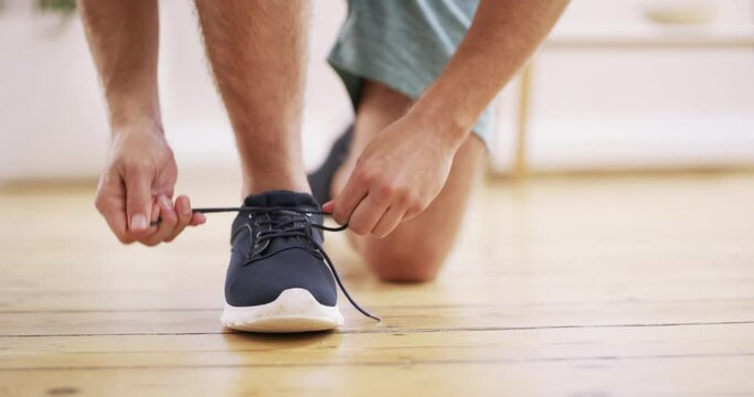 Tying laces, fitness and feet of a person for exercise, running or a workout in a house. Floor, start and an athlete with shoes and shoelaces for sports, cardio and training on the ground in a lounge