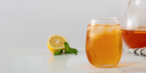 A glass with a summer cooling drink. Iced tea with lemon and mint. Copy space