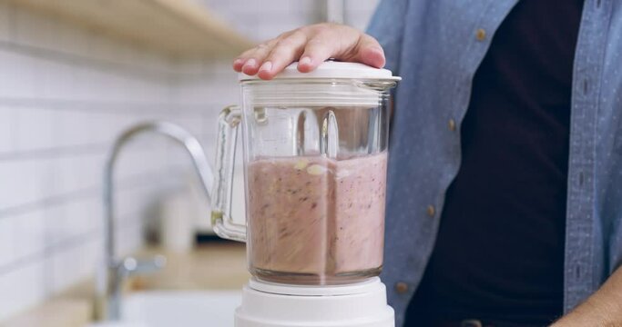 Smoothie, blender and hands of a man with healthy food in home kitchen for vegan diet, nutrition or protein. Male person making a fruit cocktail or drink with appliance for wellness, detox and health
