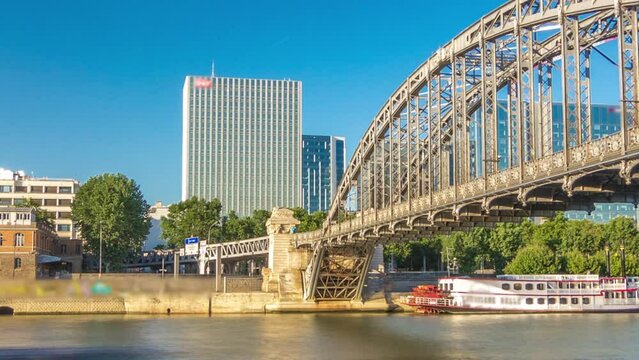 The Austerlitz viaduct in Paris timelapse hyperlapse, seen from waterfront with a metro train passing, is a single-deck, steel arch, rail bridge that was built in 1904
