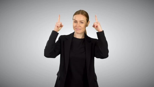 A business woman in black pointing up with two fingers