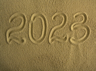Signpost 2023 written in sand. There is space for text.