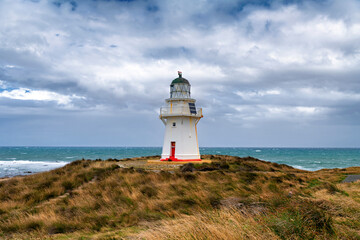 Waipapa Point lighthouse on the South Island of New Zealand in rough, stormy seas