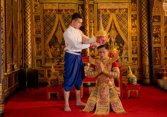 Asian man with Thai style cloth hold Khon mask and stand with action for traditional ceremony of...