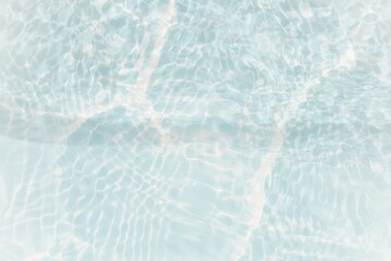 Blue water with ripples on the surface. Defocus blurred transparent blue colored clear calm water surface texture with splashes and bubbles. Water waves with shining pattern texture background.