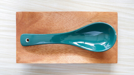 A soup spoon present above the wooden ware at the table.