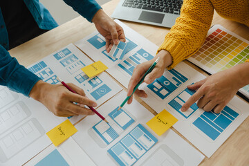 Close up ux developer and ui designer brainstorming about mobile app interface wireframe design on...