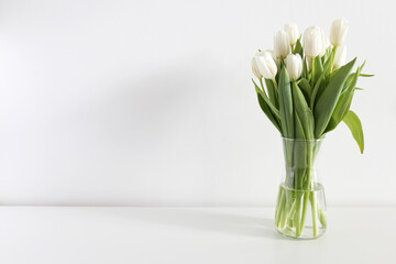 bouquet of white tulips in a vase on a white background