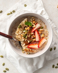 Portion of healthy oatmeal porridge with strawberries and banana