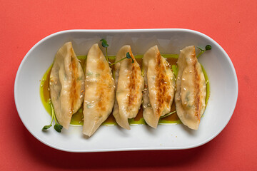 Portion of japanese gyoza dumplings on pink background