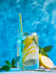 summer cold lemonade with lemon and mint, blue background.