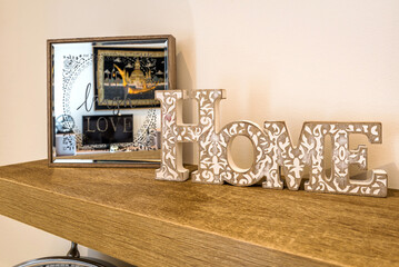 Interior decoration element. Wooden wall shelf with word home.