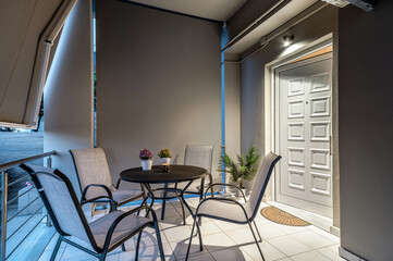 Outdoor terrace with modern grey furniture table and four chairs for relax, breakfast, lunch and dinner.