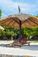 Thatched umbrella and chairs on tropical beach in Khanh Hoa, Vietnam