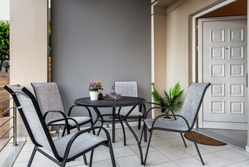 Outdoor terrace with modern grey furniture table and four chairs for relax, breakfast, lunch and dinner. 