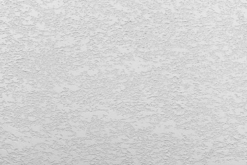 White-gray uniform background of decorative 2 layer plaster on the wall.