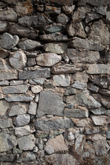 Vertical grunge background of natural stones bonded with cement mortar.