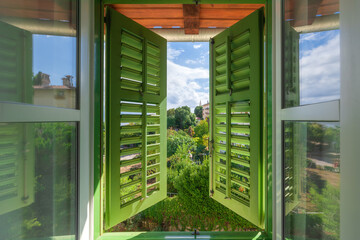 Open window with green wooden shutters with view of the Lovran, travel destination at Istrian...