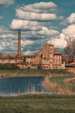 Old ruined factory building at lakeside on sunny spring day