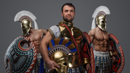 Portrait of ancient warlord fromt greece and two greek warriors with shields.