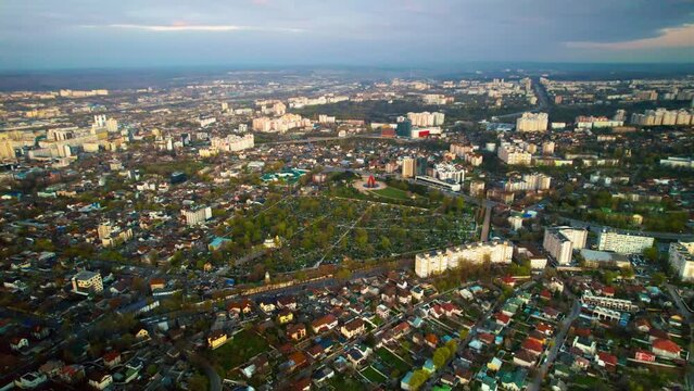 Aerial drone view of Chisinau at sunset, Moldova. Downtown with Central Cemetery and Eternity Memorial Complex, multiple residential buildings around, greenery