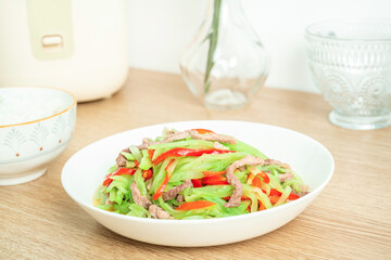 A home-cooked dish lettuce shredded fried meat on the table
