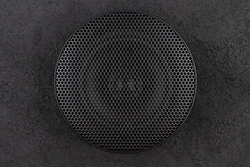 Stylish car audio acoustic round speaker with waffle grill protector cover on dark black background...