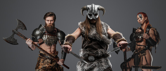 Shot of isolated on grey background three viking from past with cold steel.