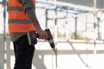 Technician holding a drill stand at a construction site.